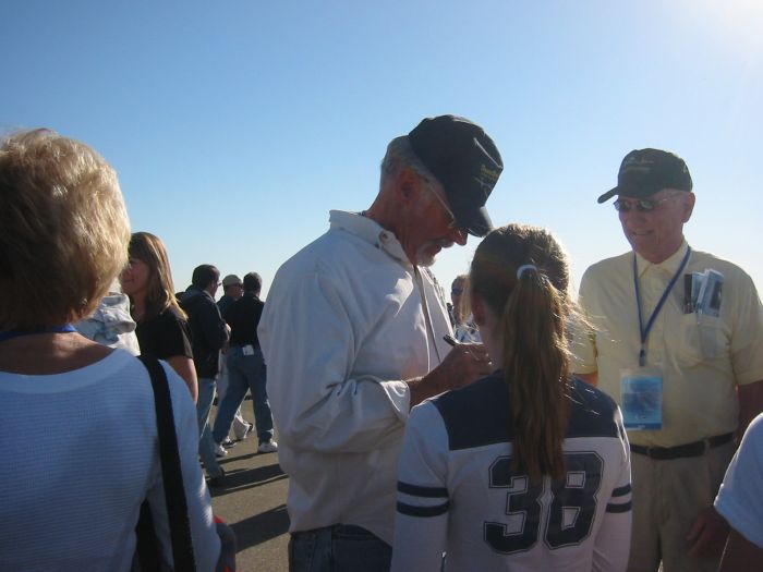 Dick Rutan signing his autograph for his granddaughter